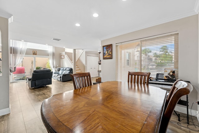 dining area with ornamental molding and light tile patterned flooring