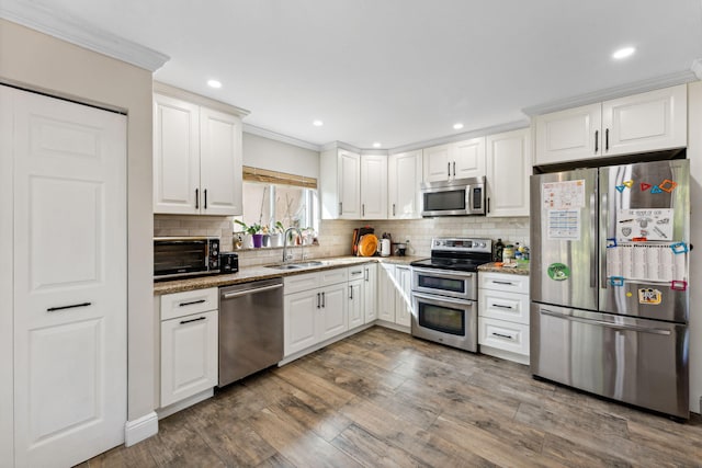 kitchen with light stone countertops, dark wood-type flooring, white cabinets, and stainless steel appliances