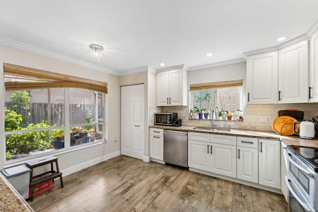 kitchen featuring white cabinetry, sink, light hardwood / wood-style flooring, stainless steel dishwasher, and crown molding