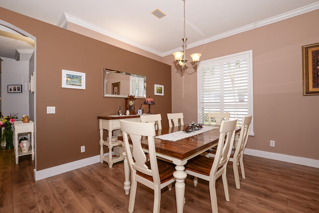 dining area with crown molding, dark hardwood / wood-style flooring, and a notable chandelier