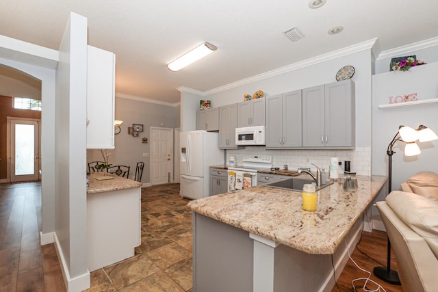 kitchen featuring kitchen peninsula, gray cabinets, dark hardwood / wood-style floors, crown molding, and white appliances