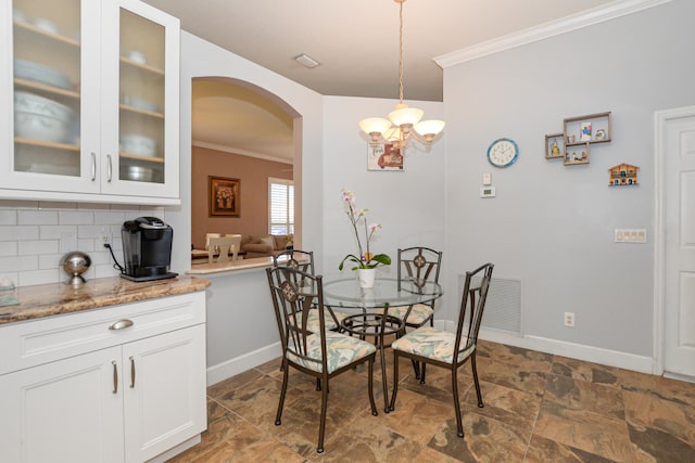 dining area with a chandelier and ornamental molding