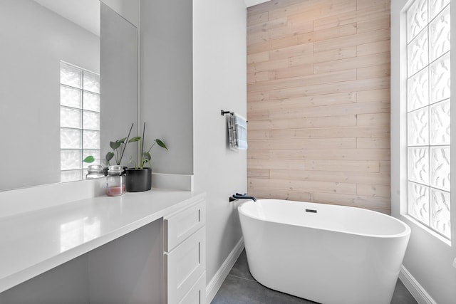 bathroom with vanity, wood walls, tile patterned flooring, and a bathing tub