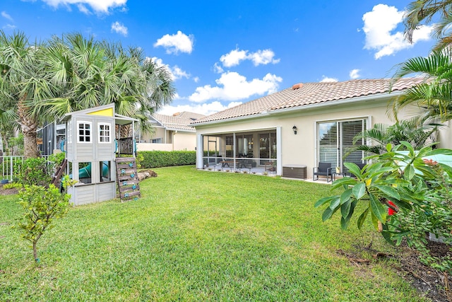 rear view of property with central air condition unit, a patio area, a sunroom, and a lawn