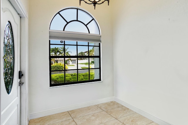 entrance foyer featuring plenty of natural light, light tile patterned floors, and a notable chandelier