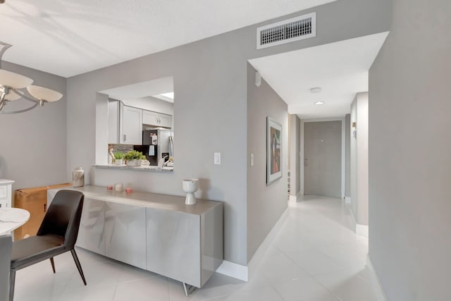 interior space with a textured ceiling and light tile patterned floors