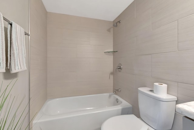 bathroom with toilet, tile walls, and tiled shower / bath