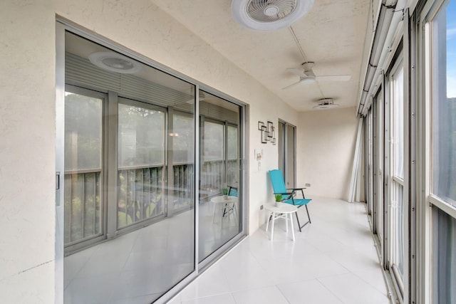 unfurnished sunroom featuring ceiling fan