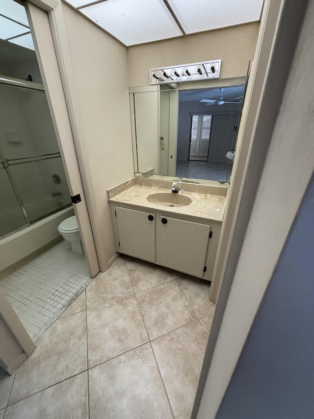 full bathroom with vanity, tile patterned floors, ceiling fan, toilet, and enclosed tub / shower combo