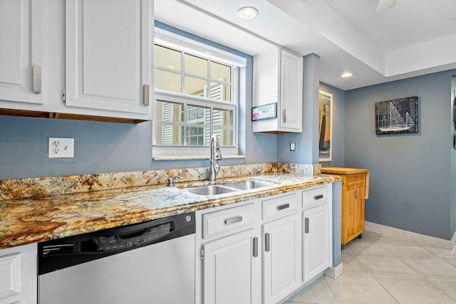 kitchen featuring light stone counters, light tile patterned floors, white cabinetry, stainless steel dishwasher, and sink