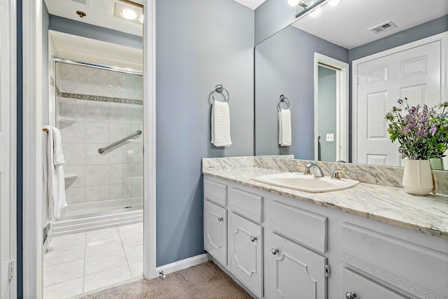 bathroom with vanity, tile patterned floors, and tiled shower