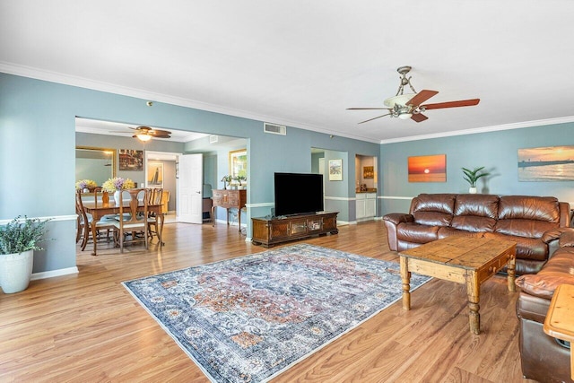 living room featuring light hardwood / wood-style floors, ornamental molding, and ceiling fan