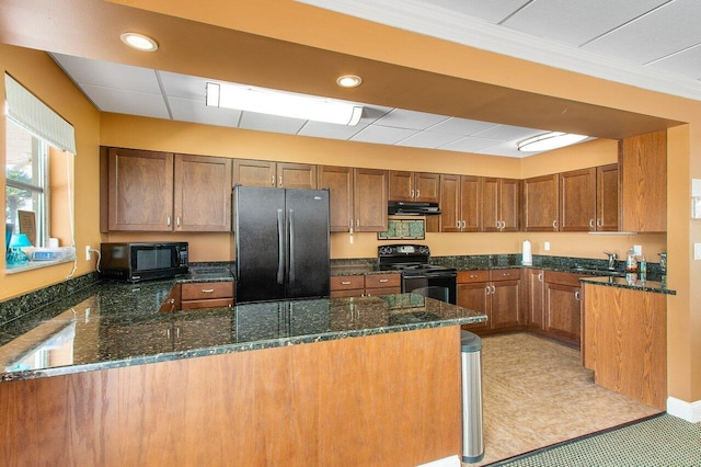 kitchen featuring sink, black appliances, dark stone counters, and kitchen peninsula