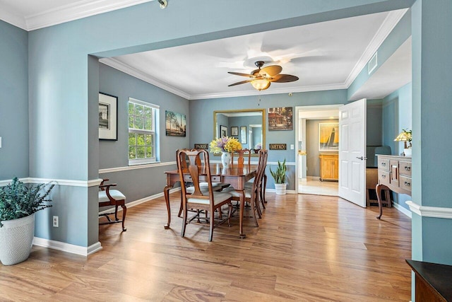 dining area with crown molding, light wood-type flooring, and ceiling fan