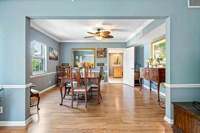 dining area with ceiling fan, crown molding, and light wood-type flooring