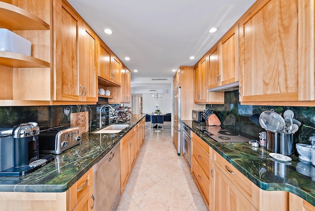 kitchen with backsplash, appliances with stainless steel finishes, and sink