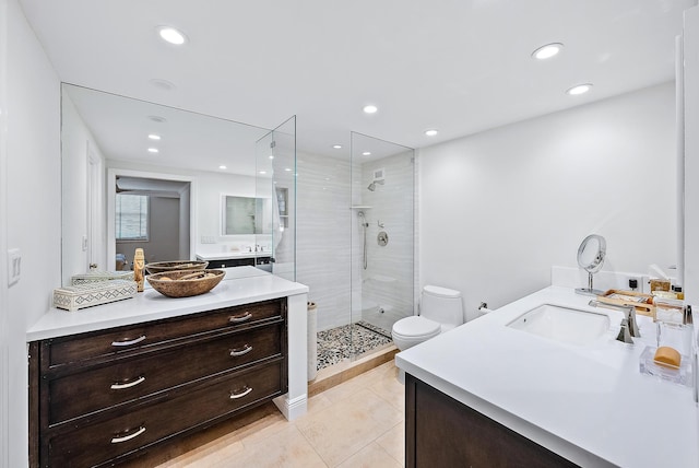 bathroom featuring vanity, toilet, tile patterned floors, and a shower with shower door