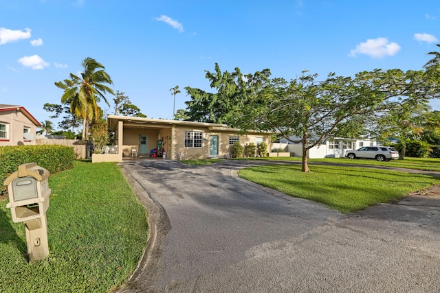 ranch-style home with a carport and a front yard