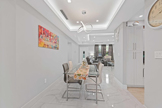 dining space featuring a raised ceiling