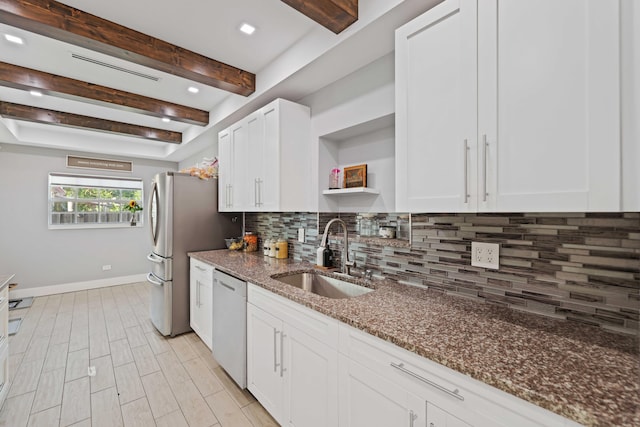 kitchen featuring sink, white dishwasher, dark stone counters, decorative backsplash, and white cabinets