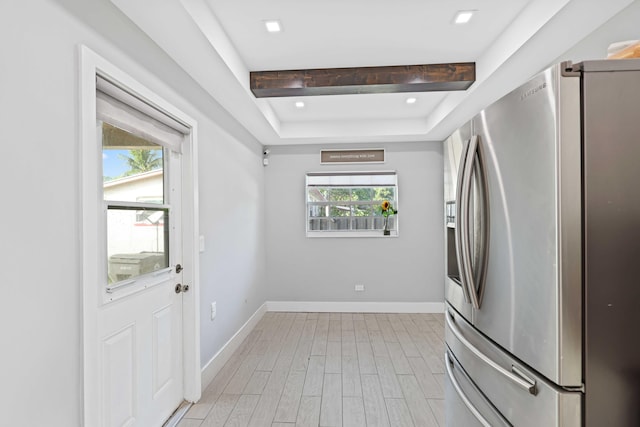 kitchen featuring stainless steel fridge with ice dispenser and a raised ceiling