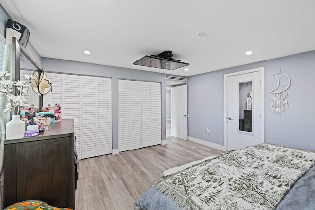 bedroom featuring light hardwood / wood-style floors and two closets