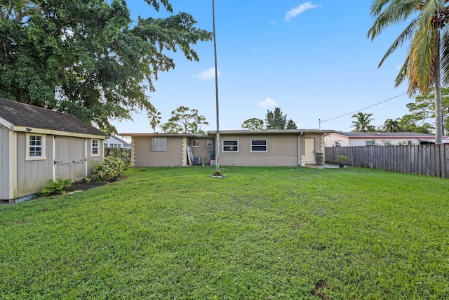 rear view of property featuring a shed and a lawn