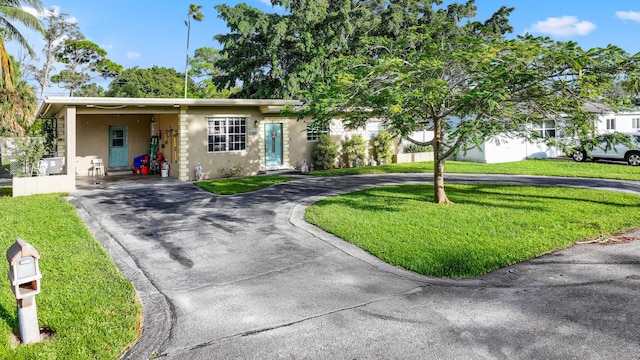 view of front of property with a carport and a front lawn