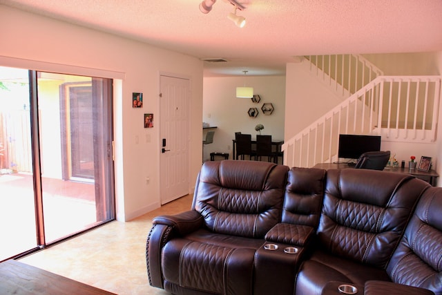 living room with a textured ceiling and track lighting