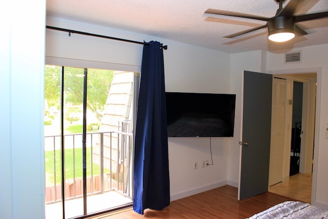 unfurnished bedroom featuring ceiling fan, a textured ceiling, light hardwood / wood-style floors, and access to exterior