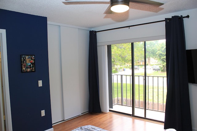 spare room with ceiling fan, a textured ceiling, light hardwood / wood-style flooring, and plenty of natural light