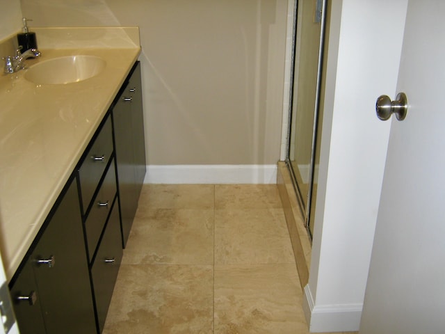 bathroom with vanity, a shower with shower door, and tile patterned floors