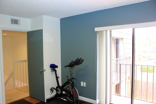 exercise room featuring a textured ceiling and hardwood / wood-style flooring