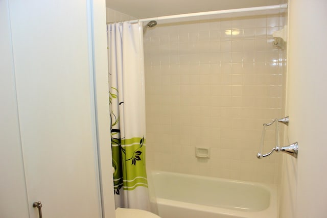 bathroom featuring shower / tub combo with curtain and toilet