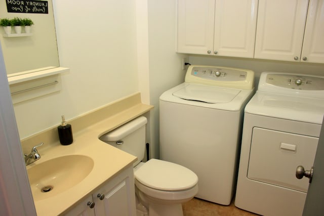 bathroom featuring vanity, washing machine and clothes dryer, and toilet