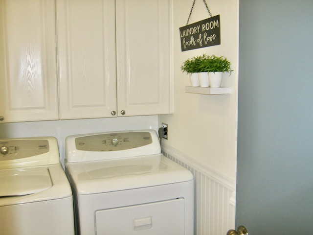 clothes washing area featuring washer and dryer and cabinets