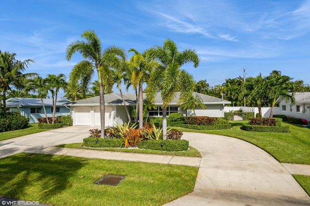 ranch-style house featuring a garage and a front lawn