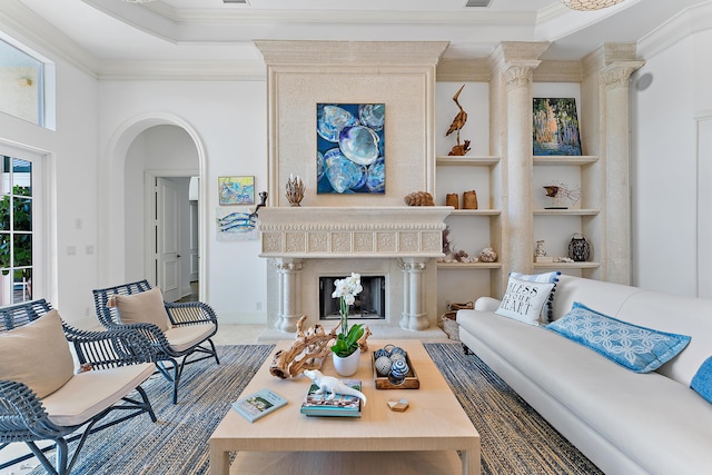 living room featuring ornamental molding, a high end fireplace, and built in shelves