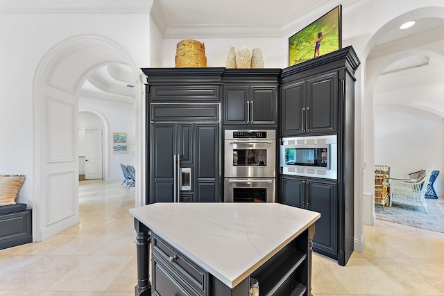 kitchen featuring light stone counters, ornamental molding, stainless steel appliances, and light tile patterned floors