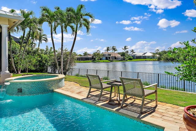 view of pool featuring a patio area, a water view, and an in ground hot tub