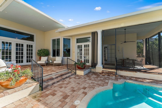 rear view of property featuring french doors, ceiling fan, and a patio area