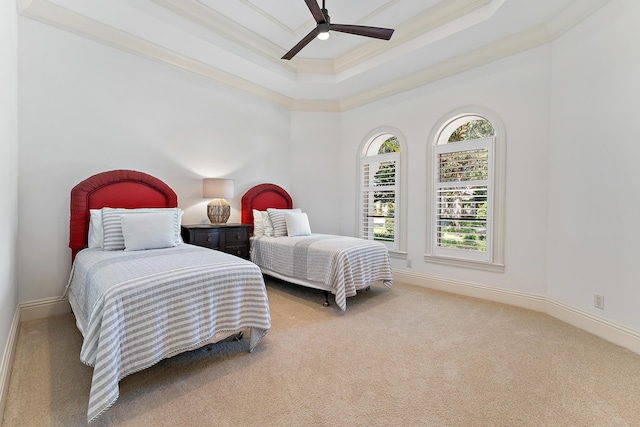 bedroom featuring a tray ceiling, ornamental molding, ceiling fan, and carpet flooring