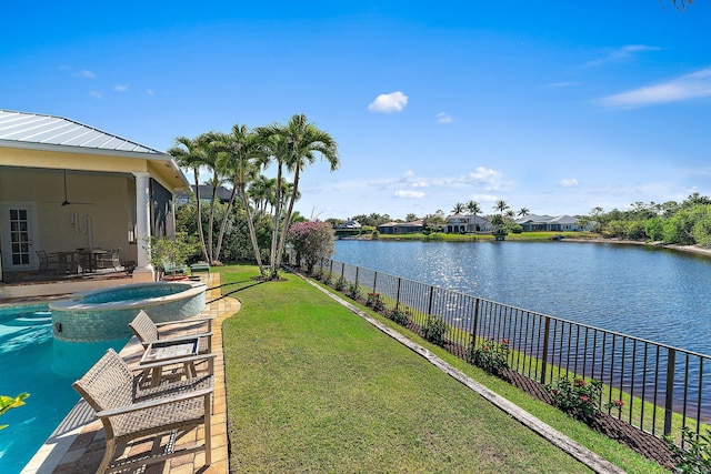 view of yard featuring a patio, a water view, ceiling fan, and an in ground hot tub