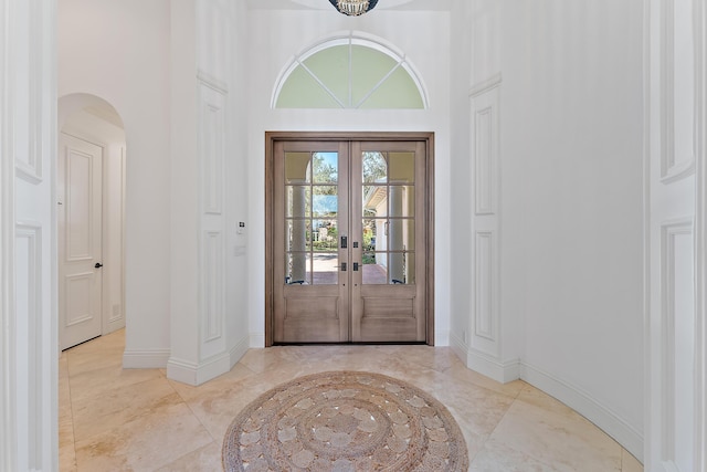 foyer with a towering ceiling and french doors