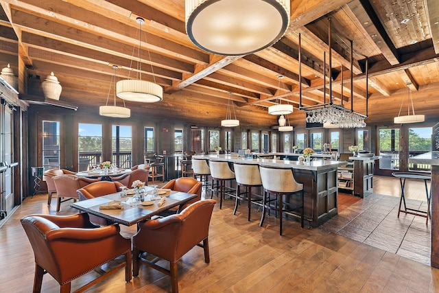 dining area featuring wood-type flooring, wood ceiling, and beam ceiling