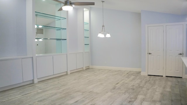 unfurnished room featuring lofted ceiling, ceiling fan with notable chandelier, and light wood-type flooring