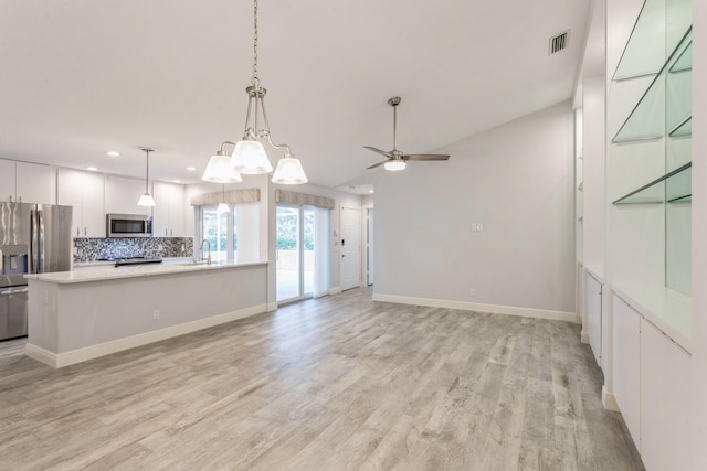 kitchen with visible vents, white cabinetry, light countertops, appliances with stainless steel finishes, and decorative backsplash