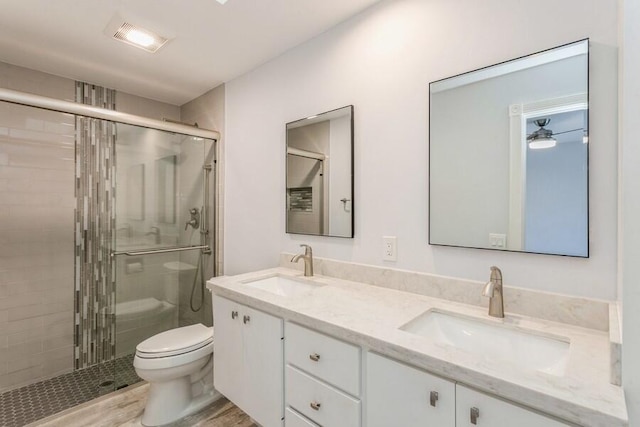 bathroom featuring walk in shower, hardwood / wood-style floors, vanity, and toilet