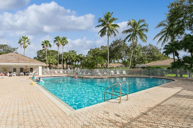 community pool featuring a patio and fence