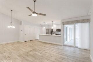 unfurnished living room featuring light wood-type flooring and ceiling fan